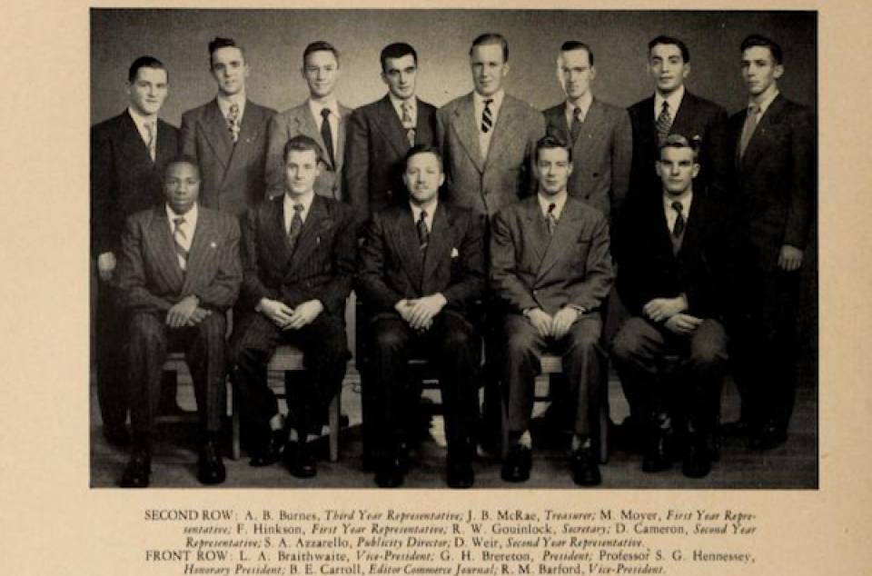 Yearbook photo of thirteen men in suits, captioned "Commerce Club"