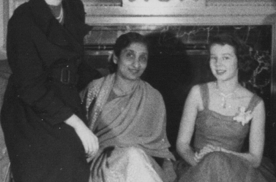 three women in front of fireplace