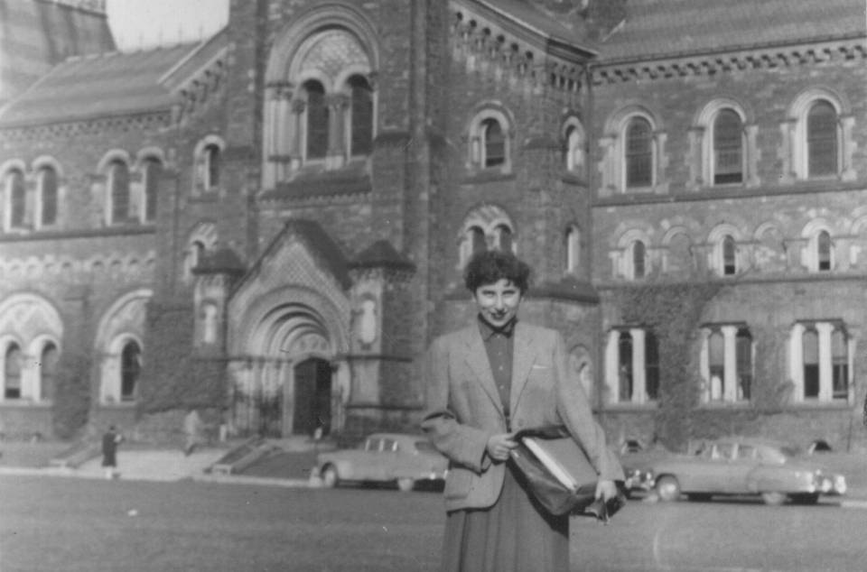 Woman standing on grass with University College in the background