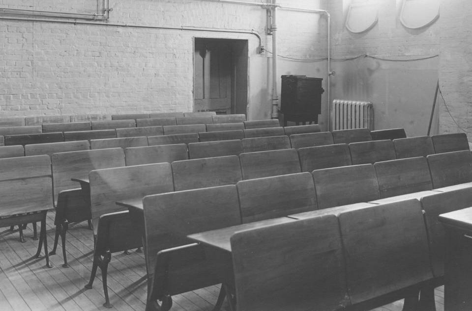 classroom with about eight rows of wooden desks