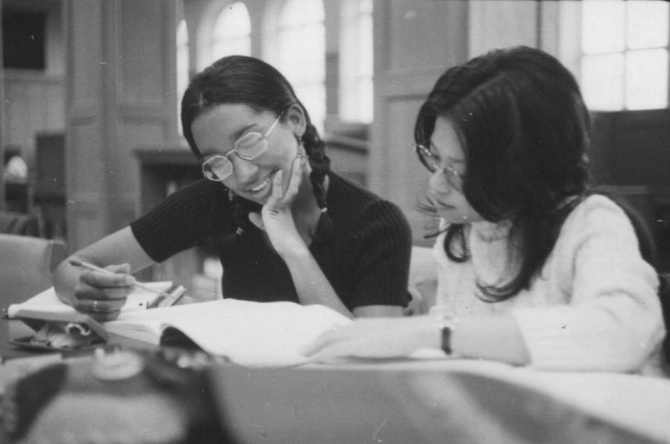 two young women studying in library