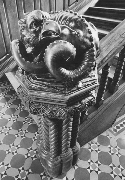 Ornate wooden carving of imaginary creature on staircase bannister