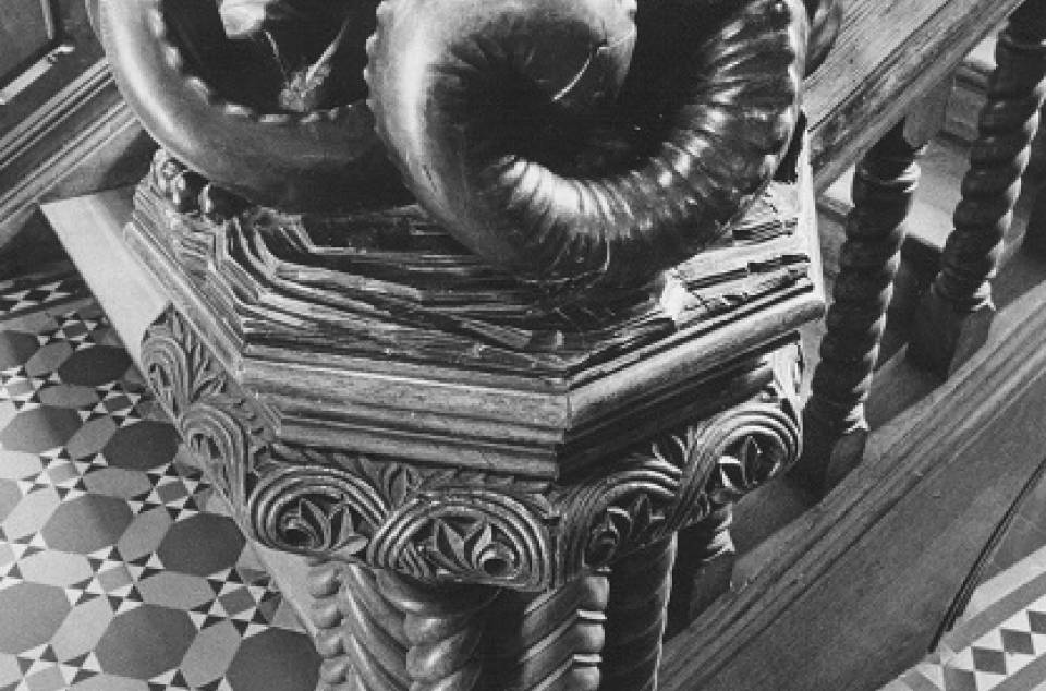 Ornate wooden carving of imaginary creature on staircase bannister