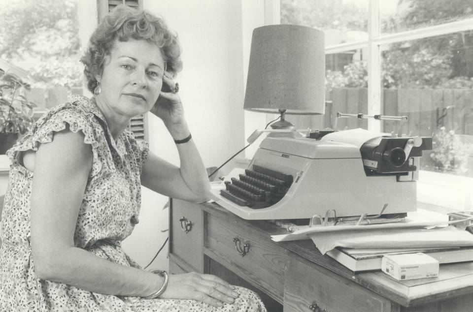 Phyllis Grosskurth seated at desk with typewriter