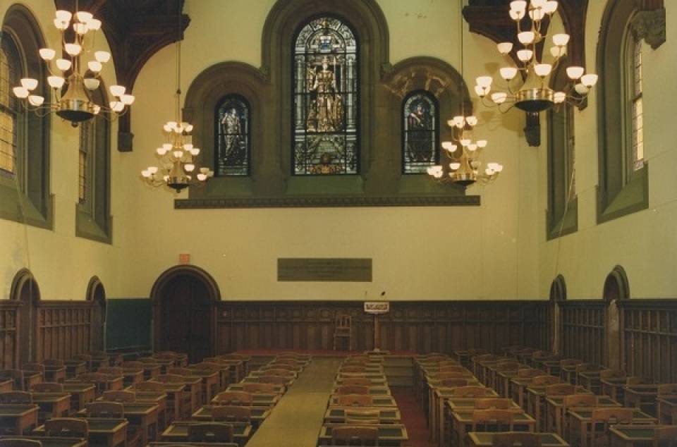 East Hall, including rows of empty desks and stained glass window