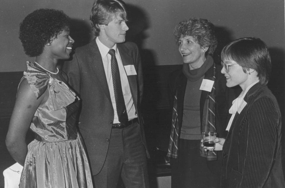 three women and one man, dressed up and wearing name tags