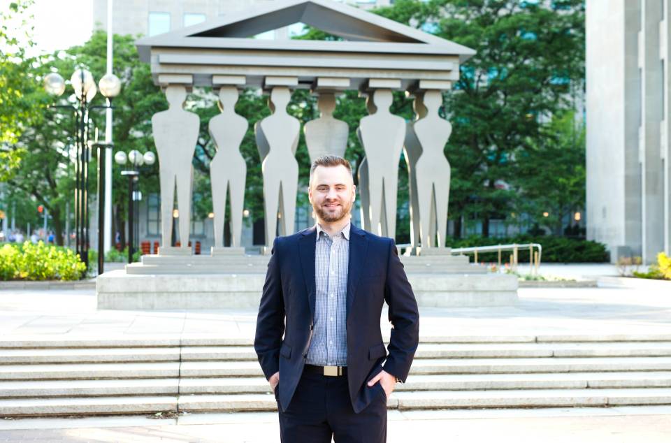 Laird Alexander Morris, UC student, stands in front of The Pillars of Justice sculpture outside the Ontario Superior Court of Justice at 361 University Avenue in Toronto, Ontario.