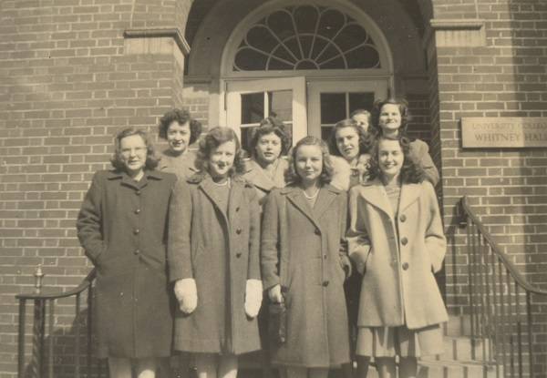 Nine young women in coats on steps outside Whitney Hall