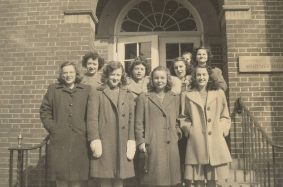 Nine young women in coats on steps outside Whitney Hall