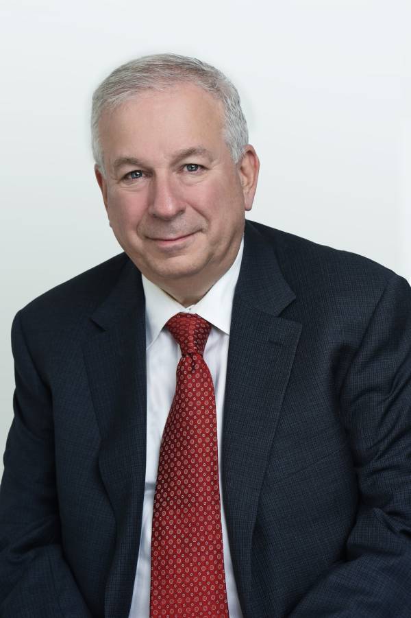 Portrait of David Rosenberg in a black suit, white shirt and crimson tie