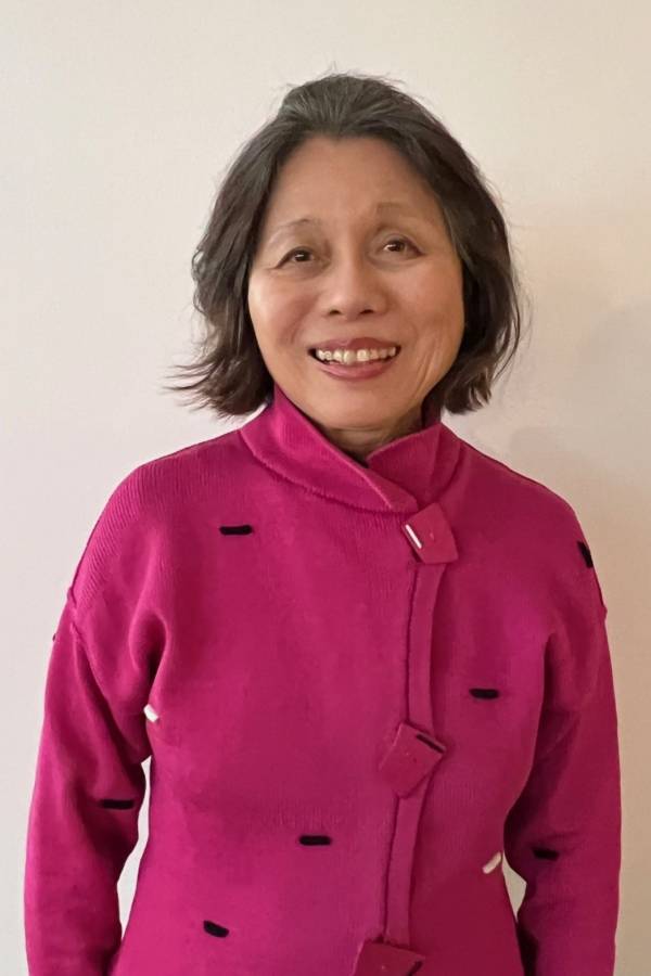 Judge Omatsu smiles for the camera. She is wearing her dark hair in a long bob and a pink jacket.