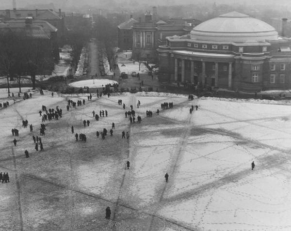 Aerial view of many people crossing front campus, with Convocation Hall in the background