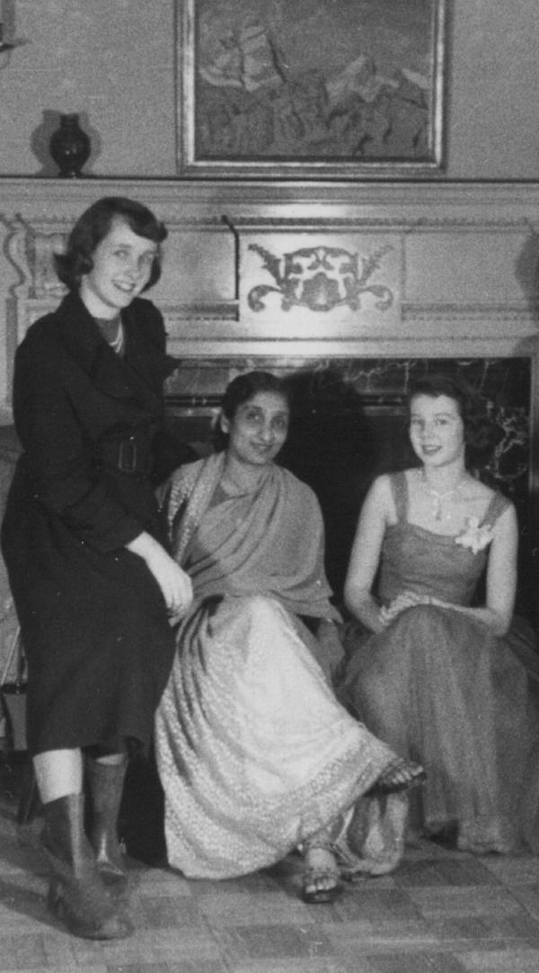 three women in front of fireplace