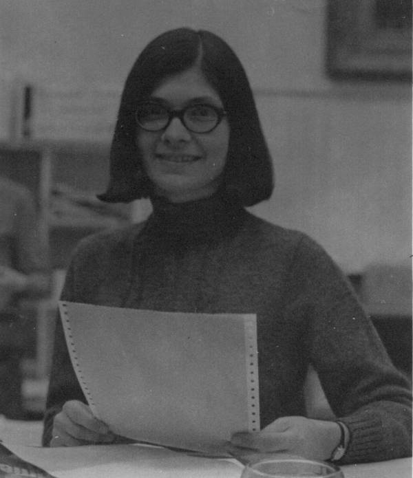 Woman seated at desk holding paper