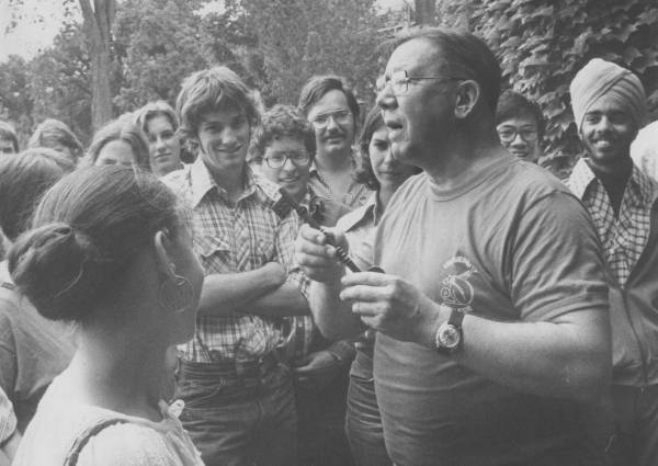 A group of students listening to a professor, who is holding a large key