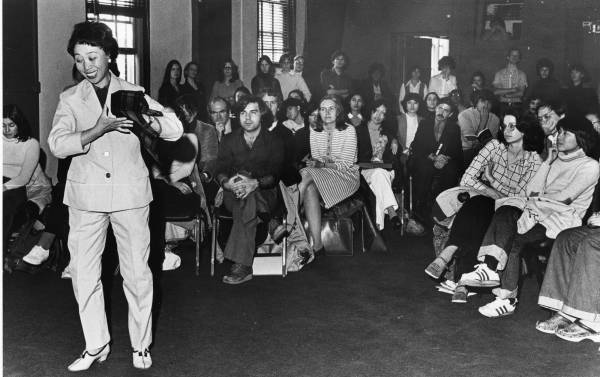 A woman performing opera, and an audience watching