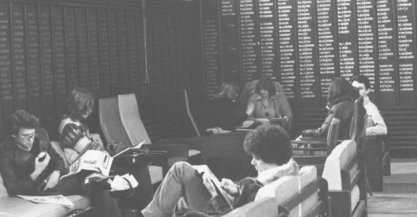 Five students reading, eating, or talking in a corner of the Junior Common Room