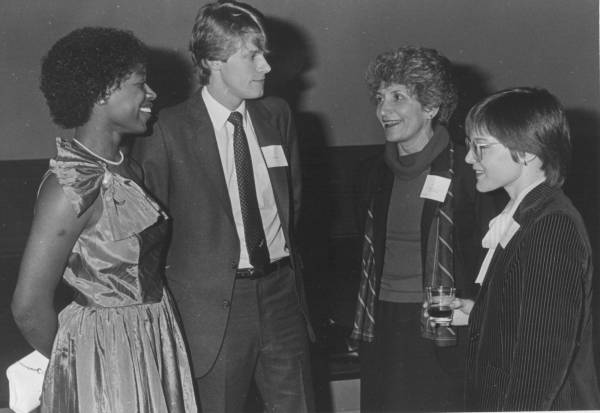 three women and one man, dressed up and wearing name tags