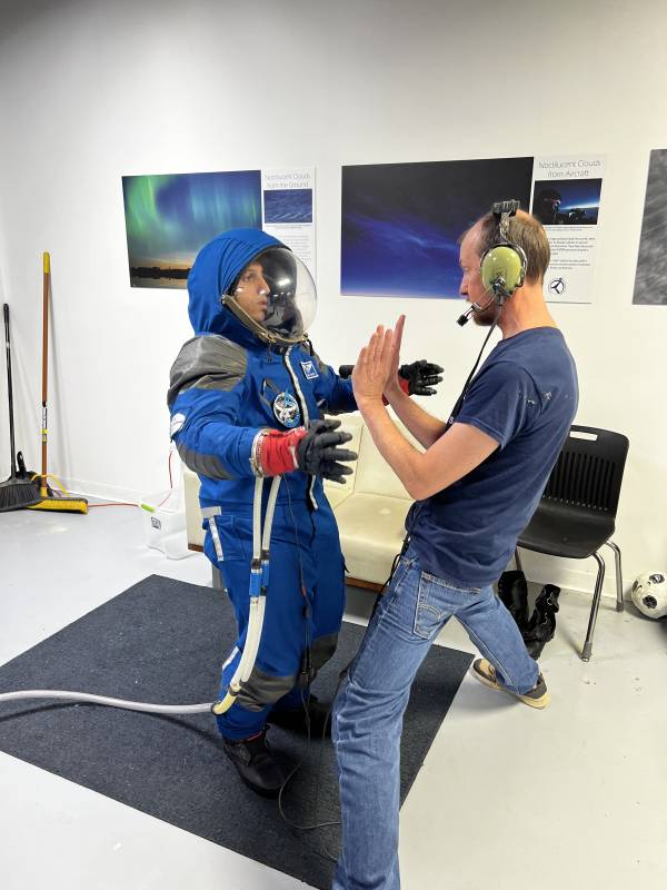 Hasaan Mohsin in spacesuit with trainer