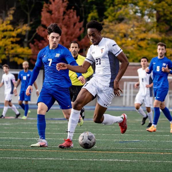 Kingsley Belele dribbling past opponent in soccer match