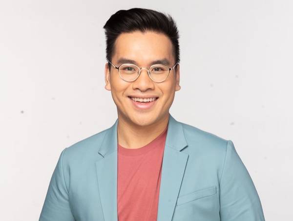 Photo of a smiling student in glasses and powder blue blazer
