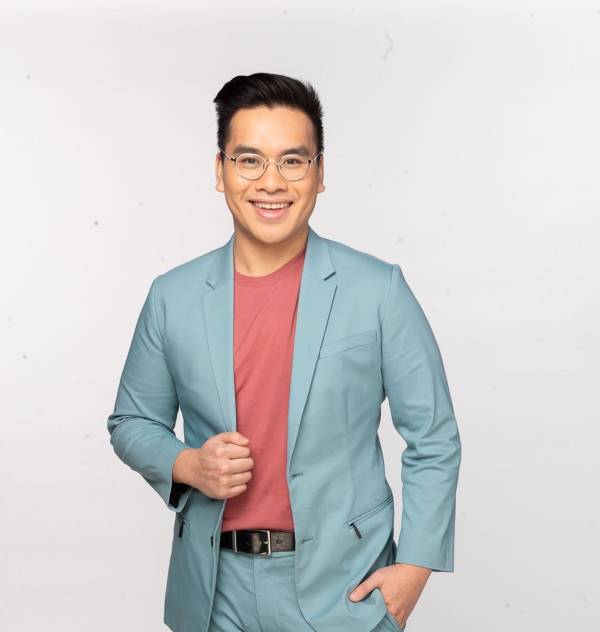 Photo of a smiling student in glasses and powder blue blazer