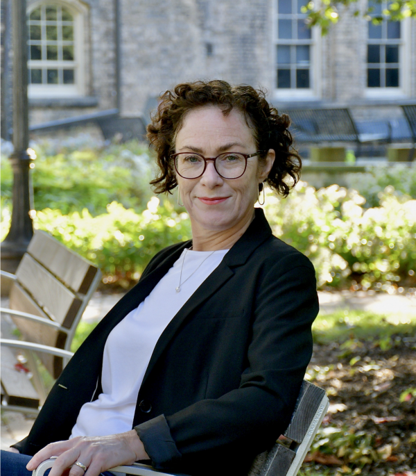 siobhan o'flynn sitting on a bench outside in sir dan's quad.