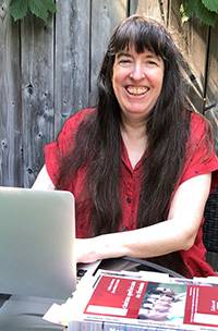 UC Librarian Margaret Fulford smiling in front of her laptop