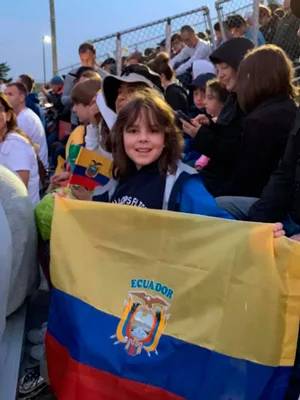 Honciuc Menendez at 11 years old at the launch of one of his experiments on a rocket with the NASA Cubes in Space program at the Wallops Flight Facility holding an Ecuador flag looking at the camera