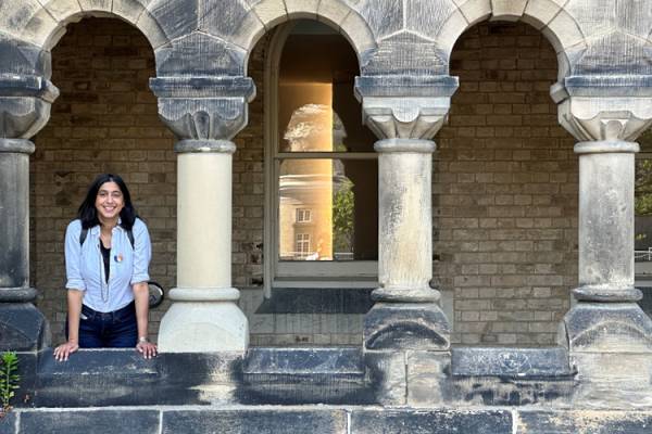 Renée Gomes standing in a stone archway outside.