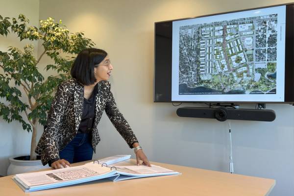 Renée Gomes looking at a diagram on a screen displaying an urban development project.
