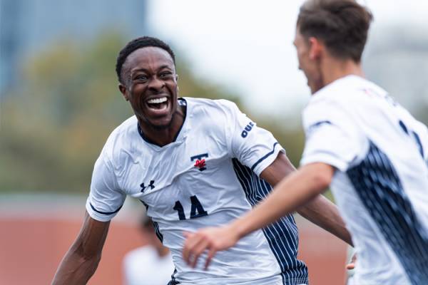 Kinglsey Belele in soccer jersey and friend excited about accomplishment