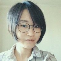 Minhui Yang, Smiling at the camera, wearing black glasses and a grey shirt.