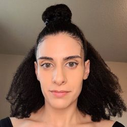 Grace Barakat, looking at the camera, with a black sweater on.