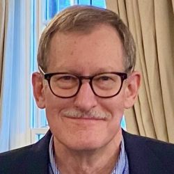 Headshot of James Reilly, smiling at camera, wearing