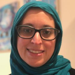 Shaza Fadel, wearing glasses, smiling at the camera.