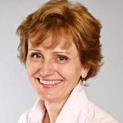 Headshot of Tamara Trojanowska, smiling at then camera wearing a light pink shirt and a silver necklace.