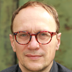 Headshot of Dirk Bernhardt-Walther, wearing red glasses and a black shirt.