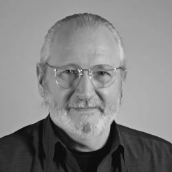 Black and white headshot of Stephen Johnson wearing glasses and a grey polo shirt.