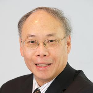 Portrait of B. Ralph Chou in a dark suit. He is smiling and wearing a small pin in his lapel.