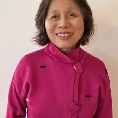 Judge Omatsu smiles for the camera. She is wearing her dark hair in a long bob and a pink jacket.